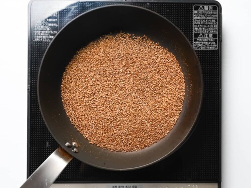 toasting white sesame seeds in a frying pan