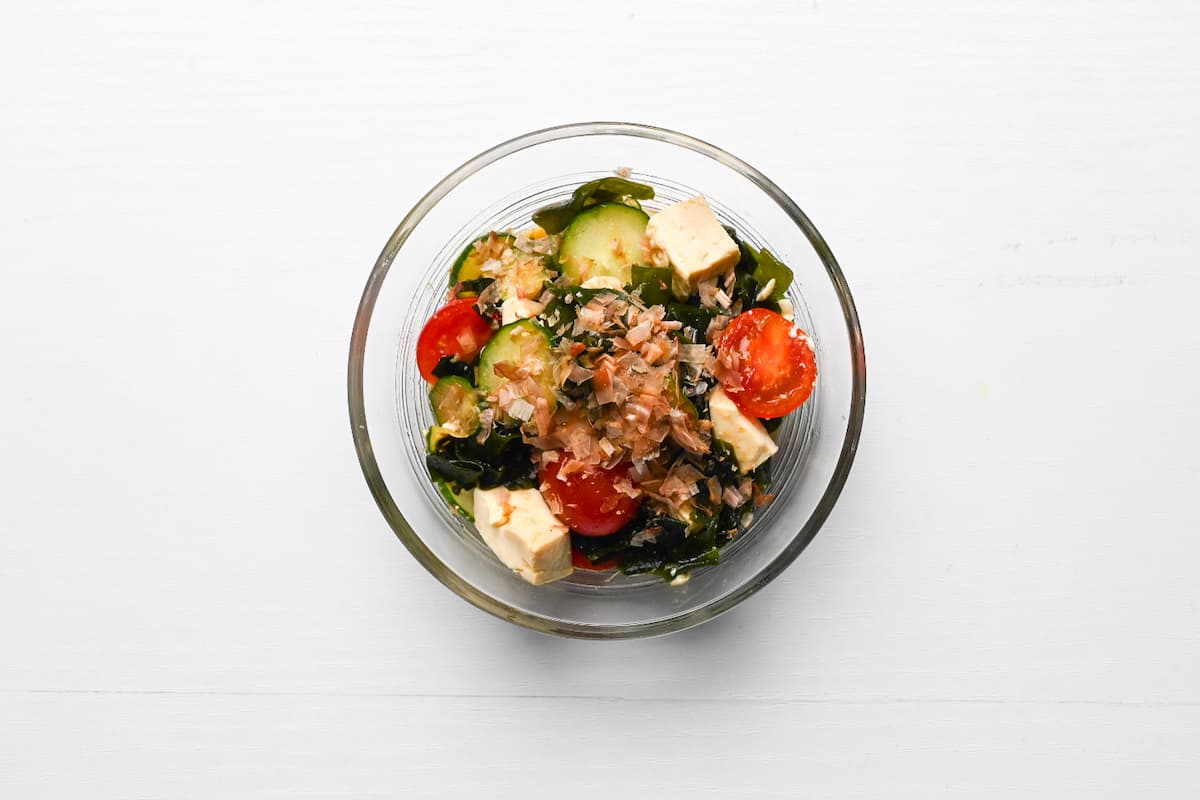 wakame salad in a glass bowl topped with bonito flakes