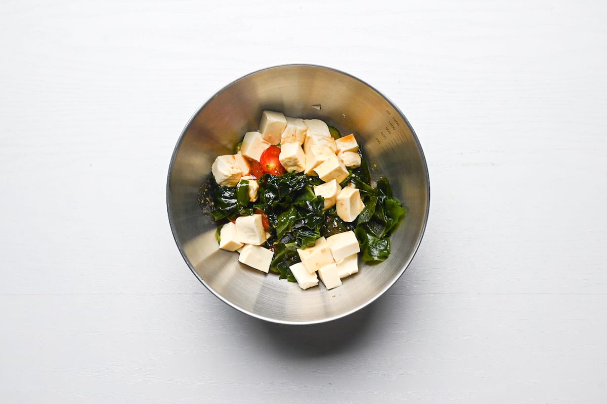 soaked wakame, silken tofu, tomatoes and cucumber in a mixing bowl