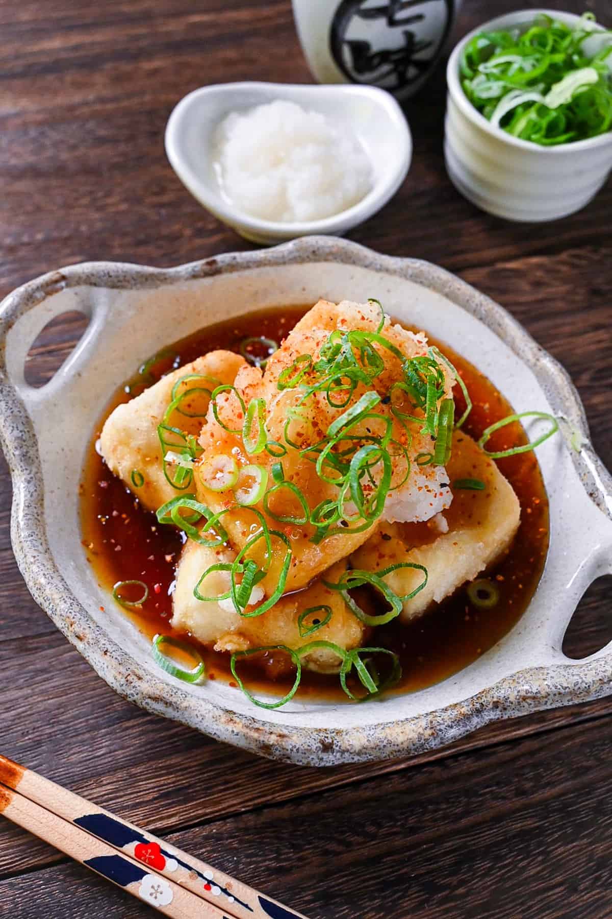 Agedashi Tofu (Japanese deep fried tofu) in a thick sauce topped with chopped spring onions, grated daikon and shichimi pepper