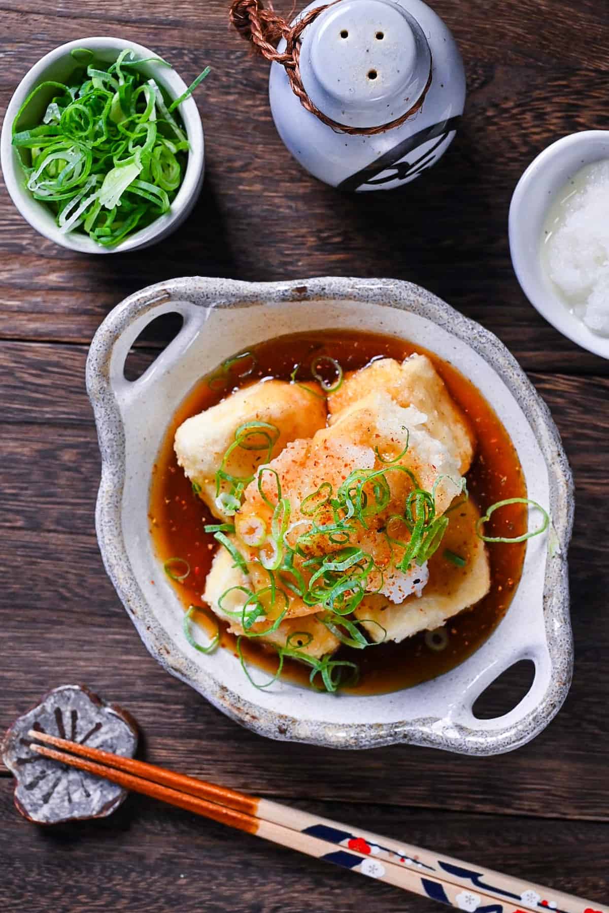 Agedashi Tofu (Japanese deep fried tofu) in a thick sauce topped with chopped spring onions, grated daikon and shichimi pepper