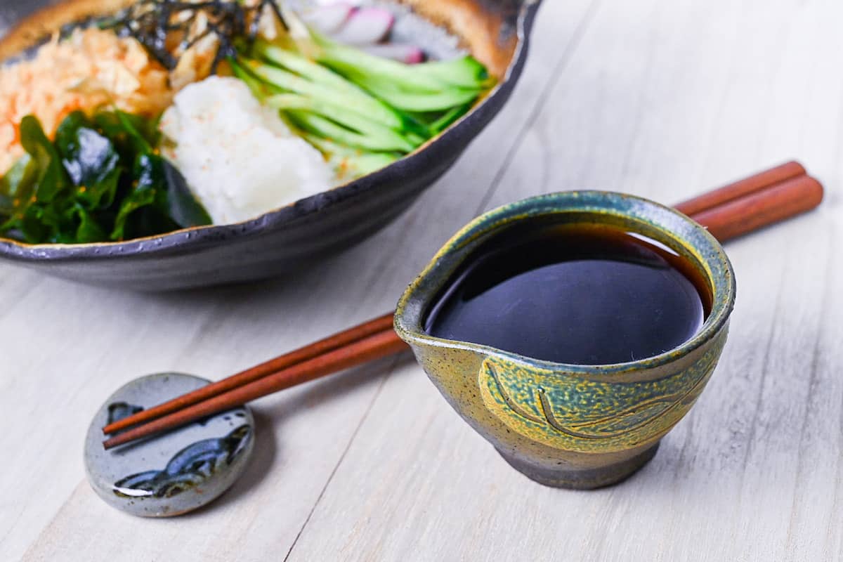 Hiyashi tanuki udon sauce in a small green pouring jug