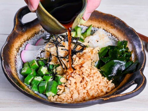 pouring sauce over hiyashi tanuki udon