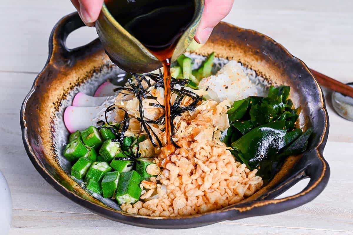 pouring sauce over hiyashi tanuki udon