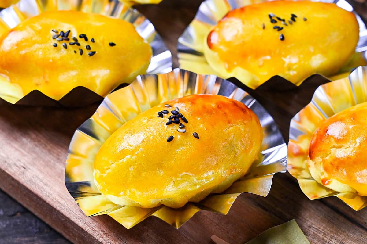 Japanese sweet potato dessert in foil cases sprinkled with black sesame seeds close up