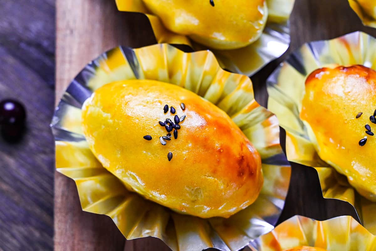 Japanese sweet potato dessert in foil cases sprinkled with black sesame seeds top down close up