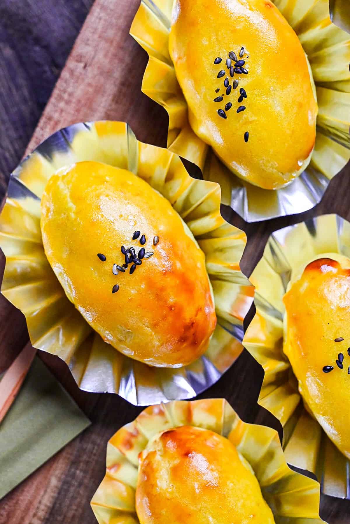 Japanese sweet potato dessert in foil cases sprinkled with black sesame seeds top down view