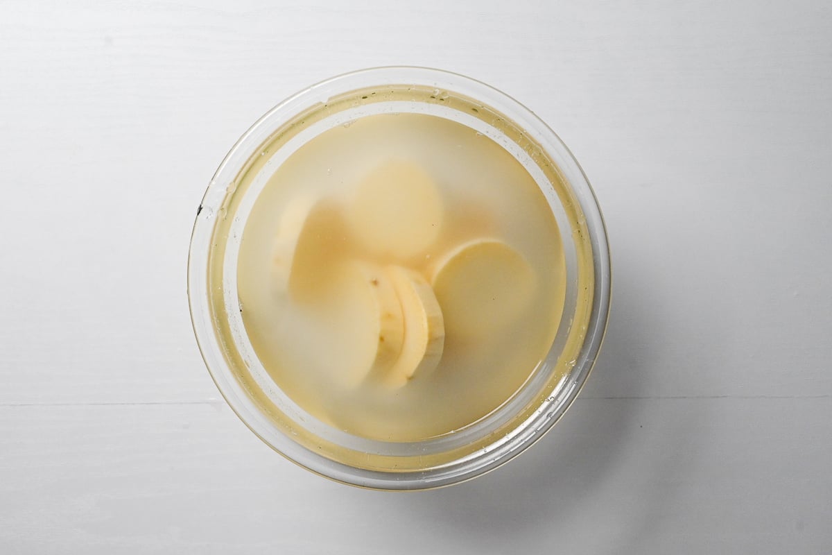 Slices of peeled sweet potato soaking in water