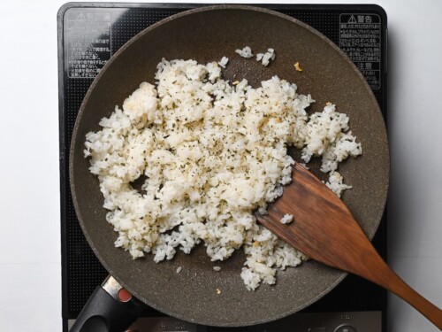 rice mixed in frying pan with dry parsley