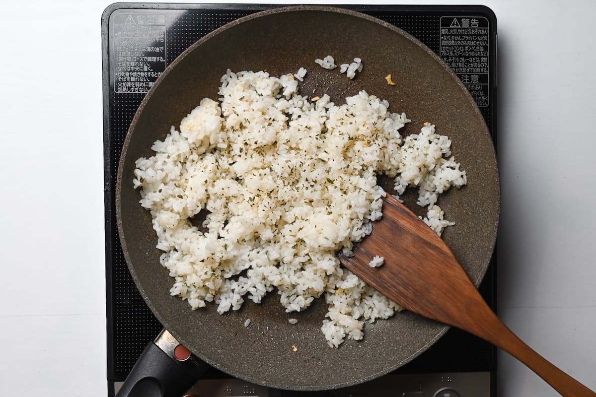 rice mixed in frying pan with dry parsley