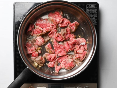 searing beef in garlic butter in a pan