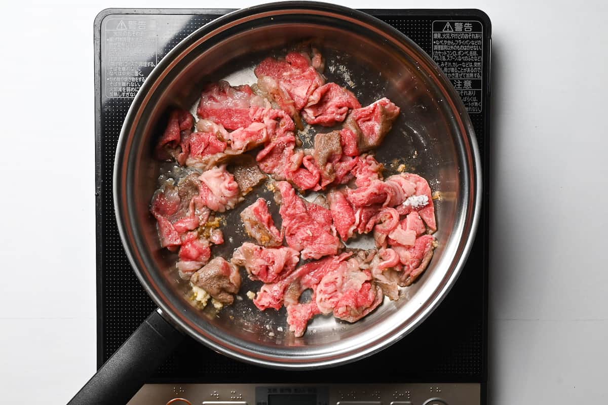 searing beef in garlic butter in a pan