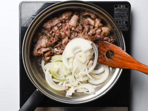 sealed beef and sliced onion in a pan