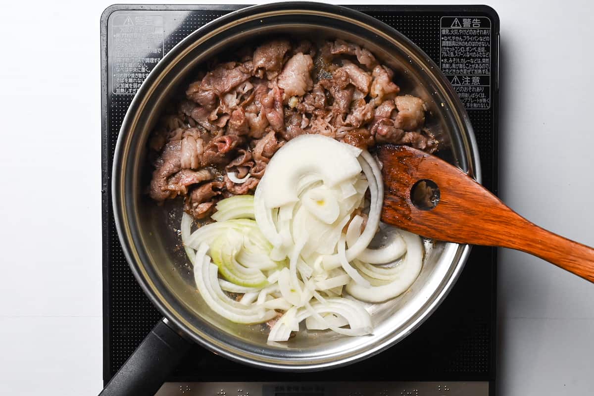 sealed beef and sliced onion in a pan