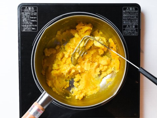 Mashed yellow sweet potato in a pan