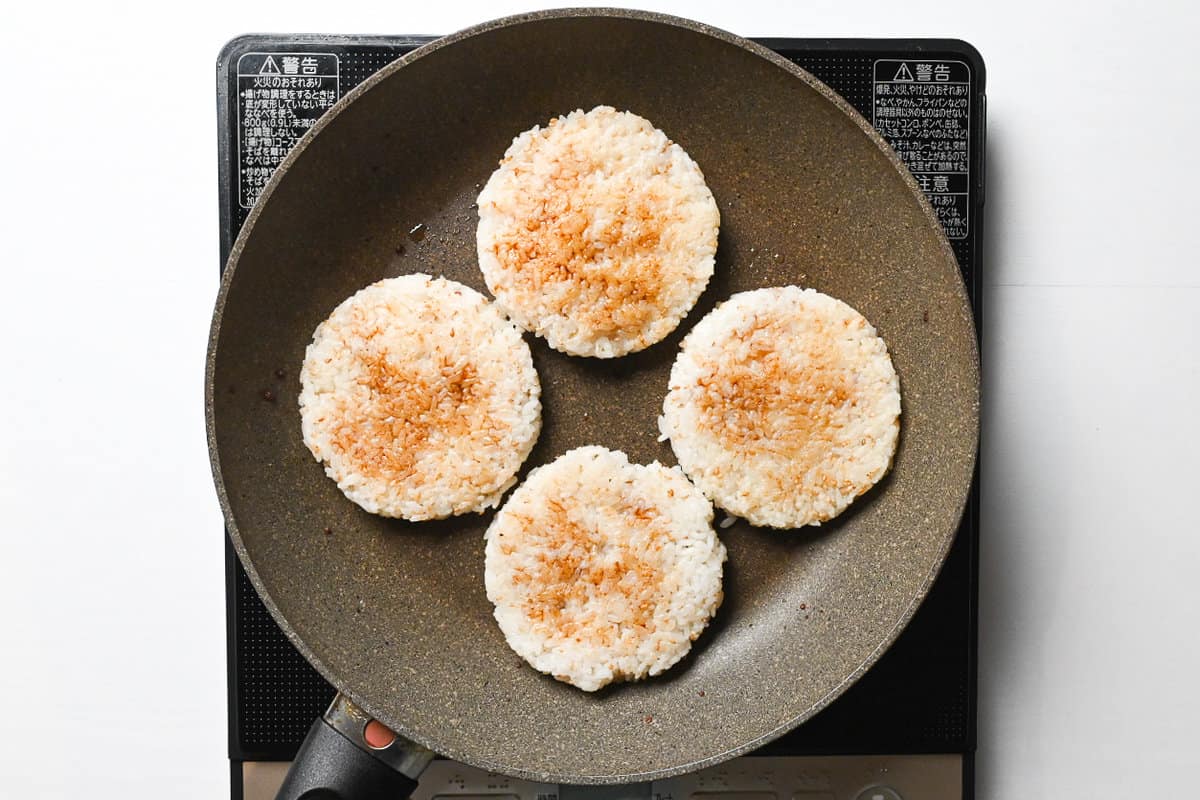 rice burger "buns" brushed with soy sauce in a frying pan