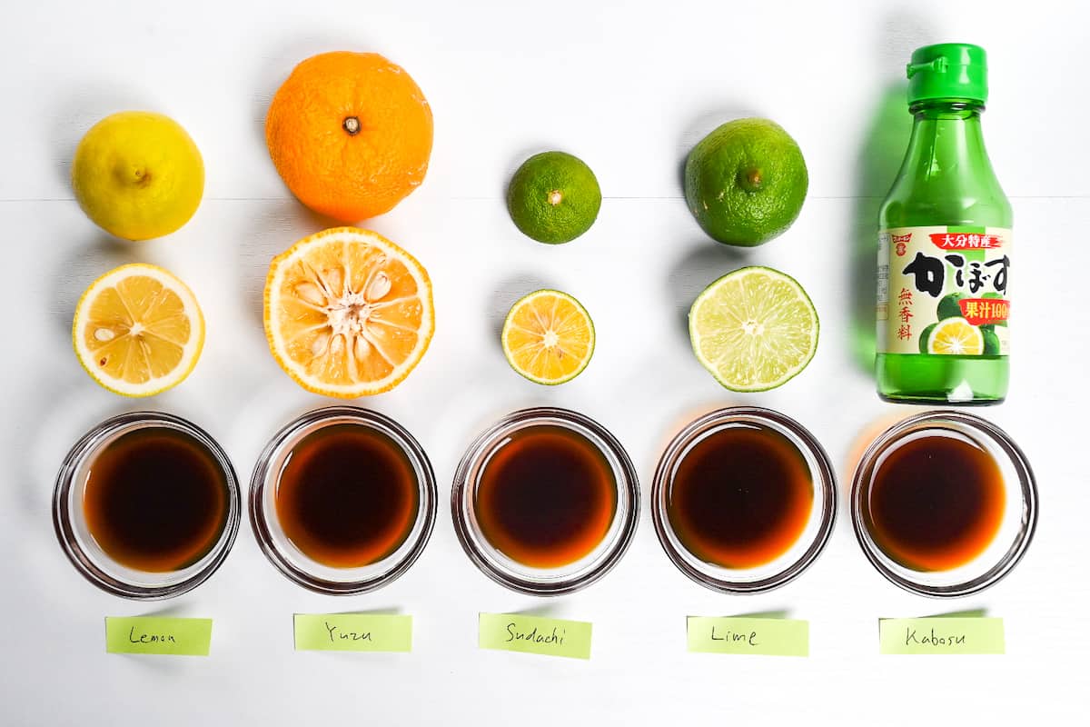 Ponzu in small glass bowls with 5 different kinds of citrus placed above them