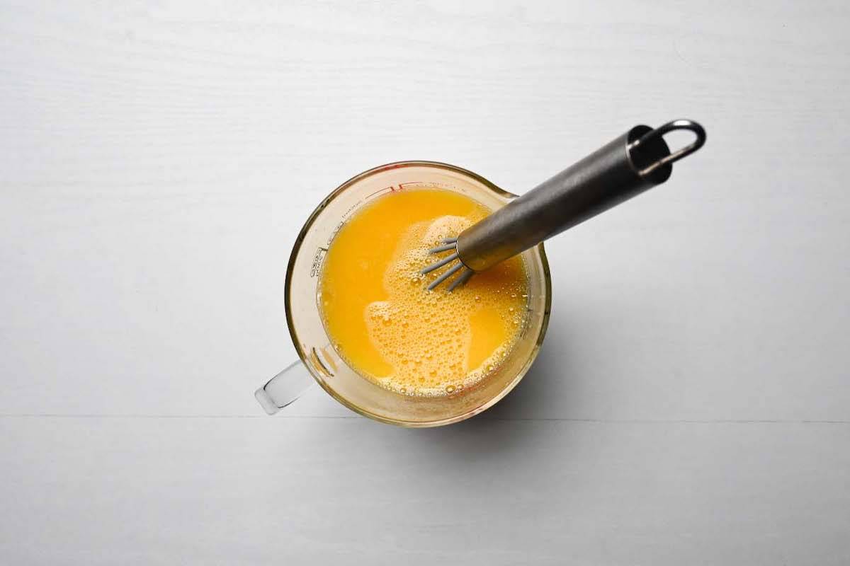 Chawanmushi mixture in a jug with small whisk