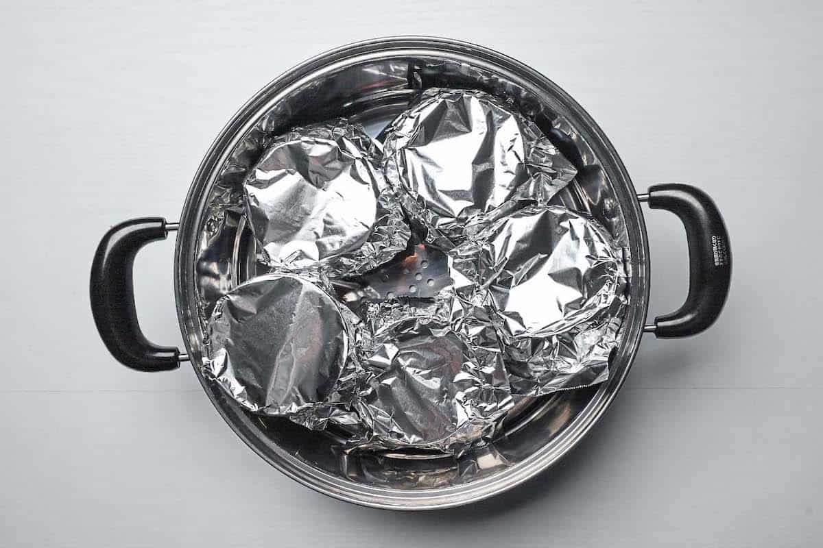 Chawanmushi covered in foil and placed in the steaming basket part of a steamer