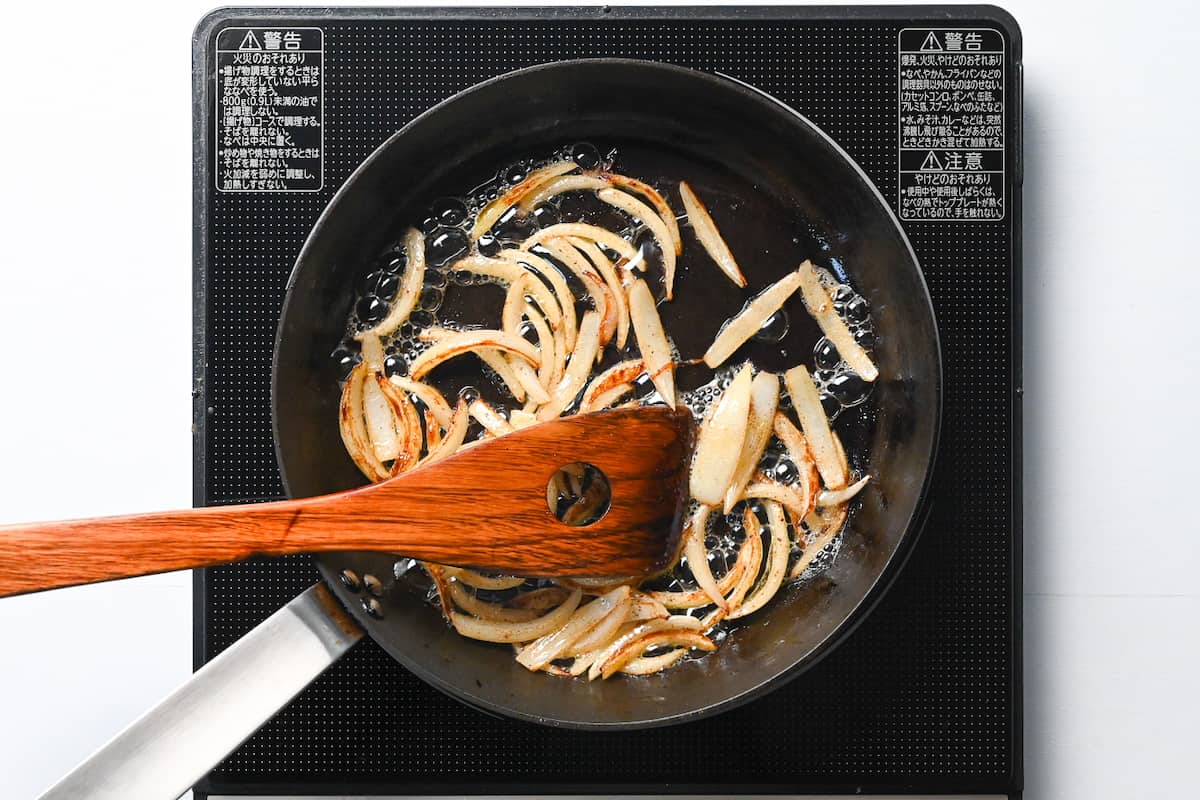 sliced onion frying in butter in a pan