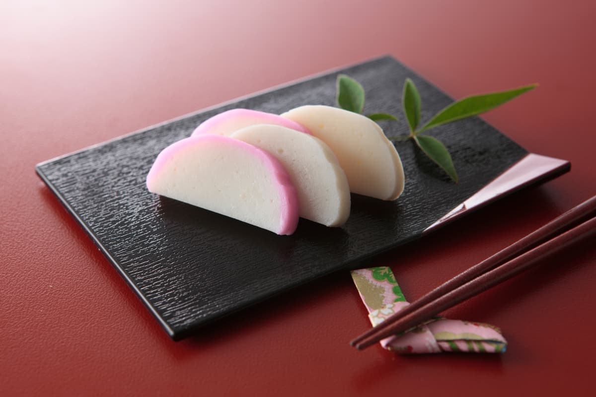 Kamaboko Japanese fishcake on a black plate with a red background
