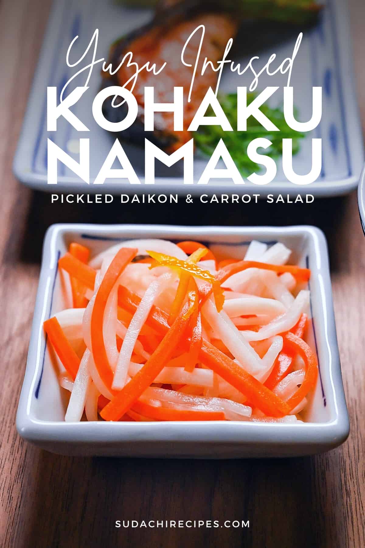 Kohaku namasu made with daikon and carrot served in a square white dish topped with yuzu peel