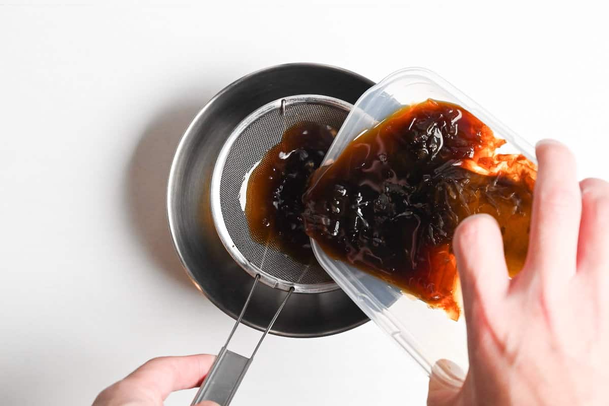 Straining ponzu through a fine mesh sieve