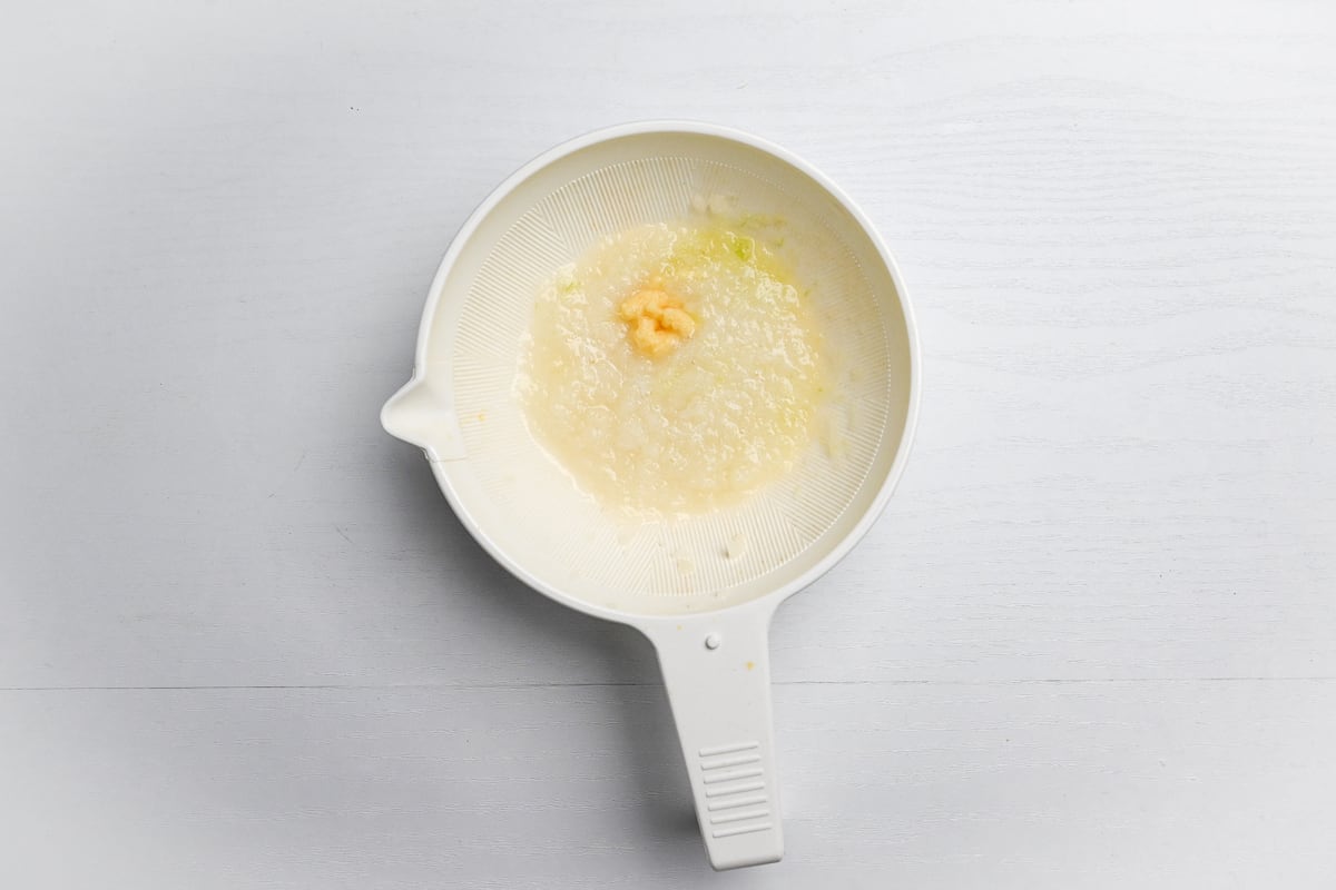 Grated onion and ginger in a white grating bowl