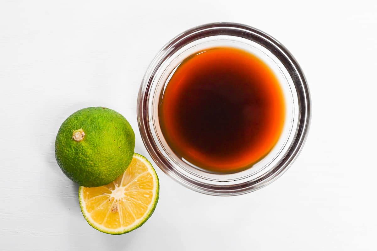 sudachi ponzu in a small glass bowl next to cut sudachi