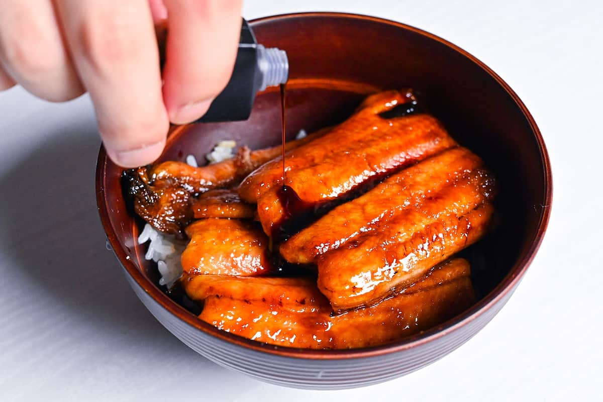 unagi don being drizzled with sweet eel sauce