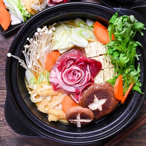 Botan nabe served in a black hot pot and made with wild boar shaped like a peony flower