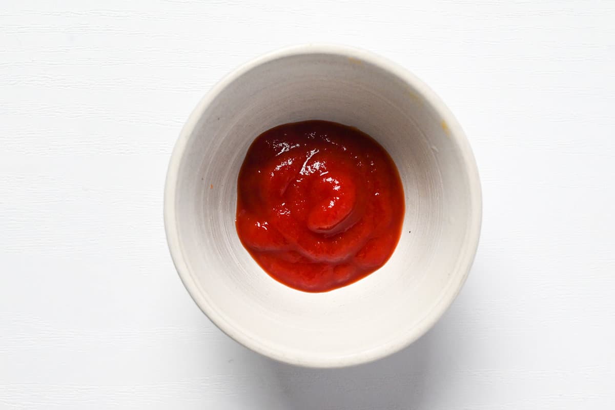 Tomato ketchup in a small white ceramic bowl