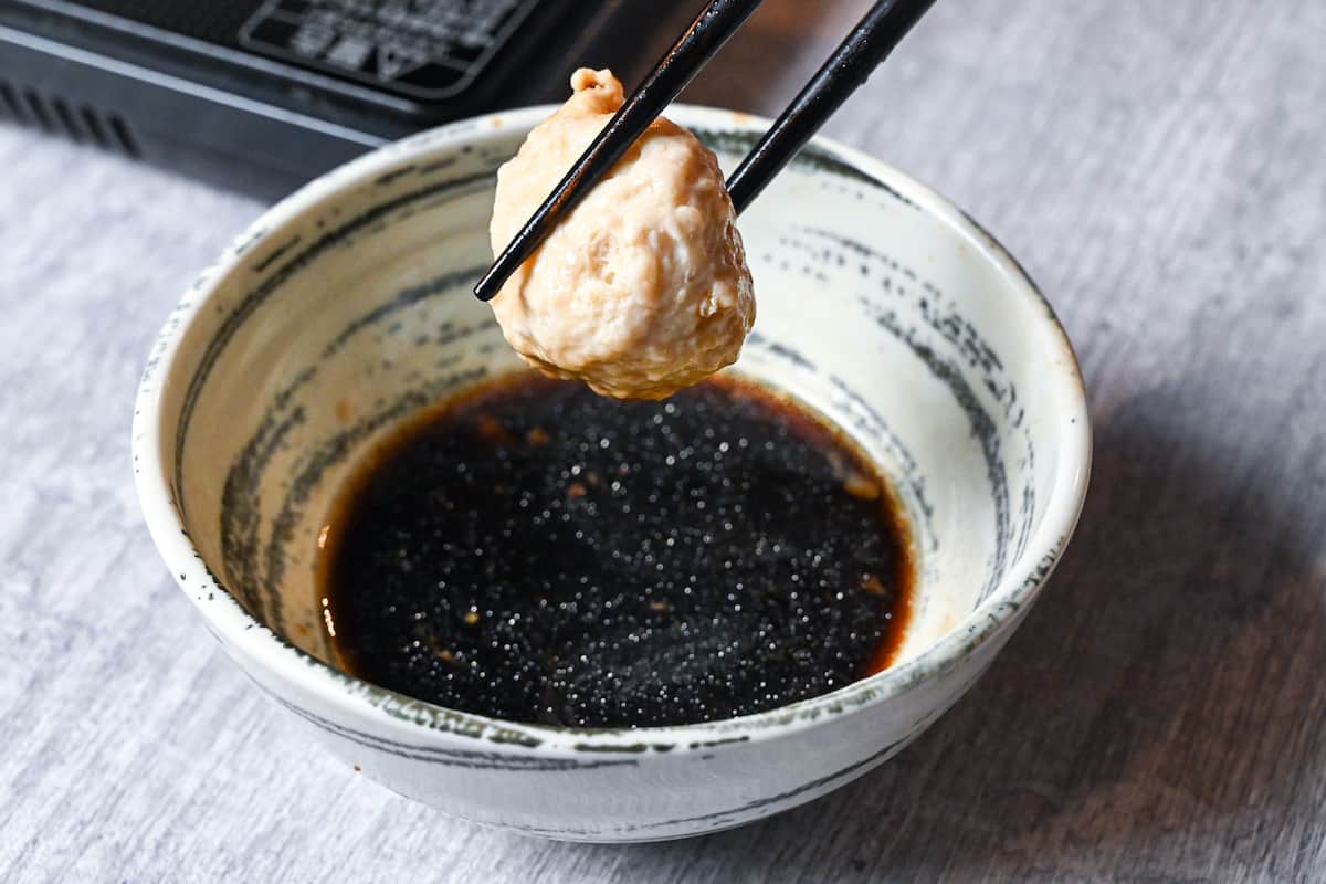 Dipping chicken meatball in ponzu sauce