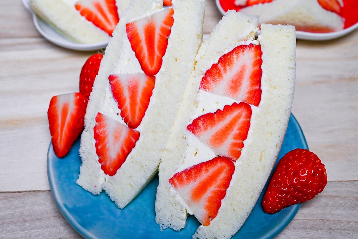 apanese ichigo sando (strawberry sandwich) cut into triangles on a blue plate