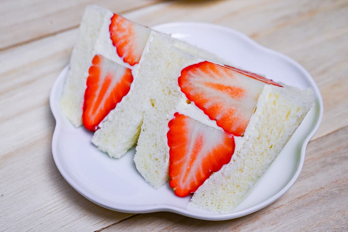 Japanese ichigo sando (strawberry sandwich) cut into triangles on a white plate
