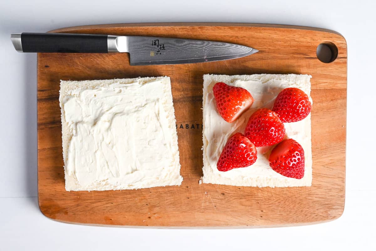 heart shaped strawberries arrange on cream and bread to make ichigo sando