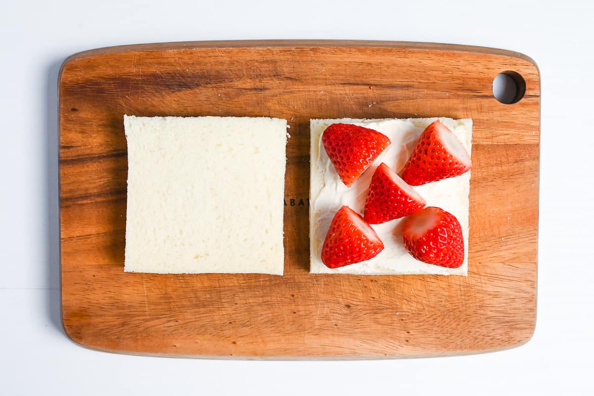 Strawberries arranged over a layer of cream on a slice of shokupan bread