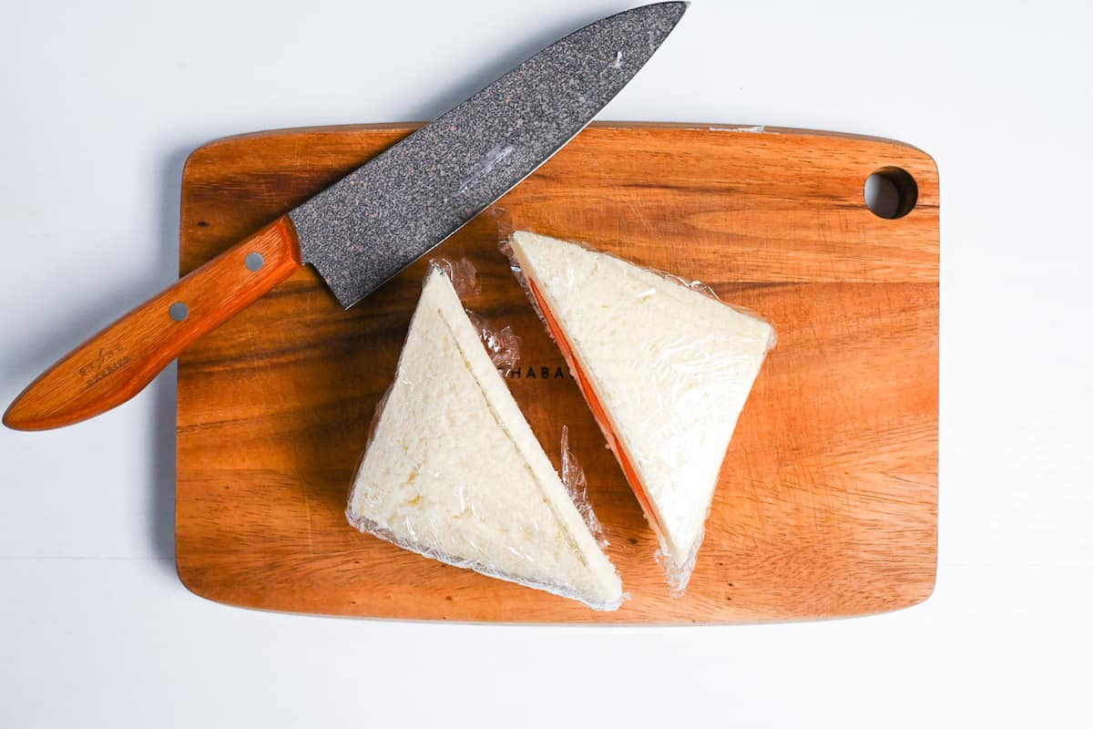 Ichigo sando cut in half on a wooden chopping board