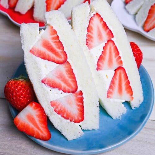 Japanese ichigo sando (strawberry sandwich) cut into triangles on a blue plate
