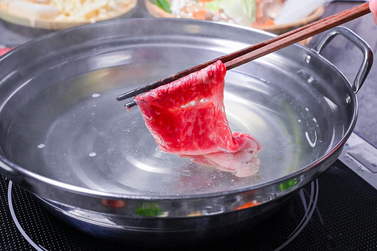 Swishing thinly sliced wagyu beef in a kombu and yuzu dashi broth