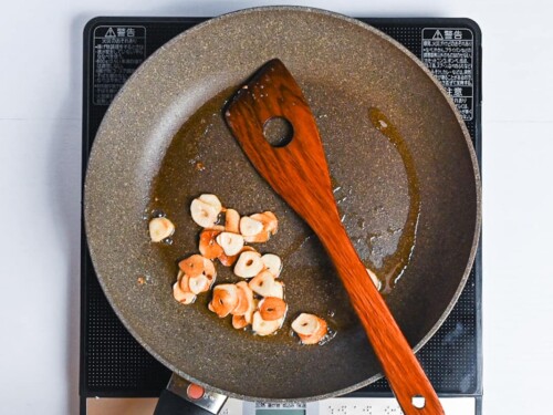 garlic slices frying in a pan
