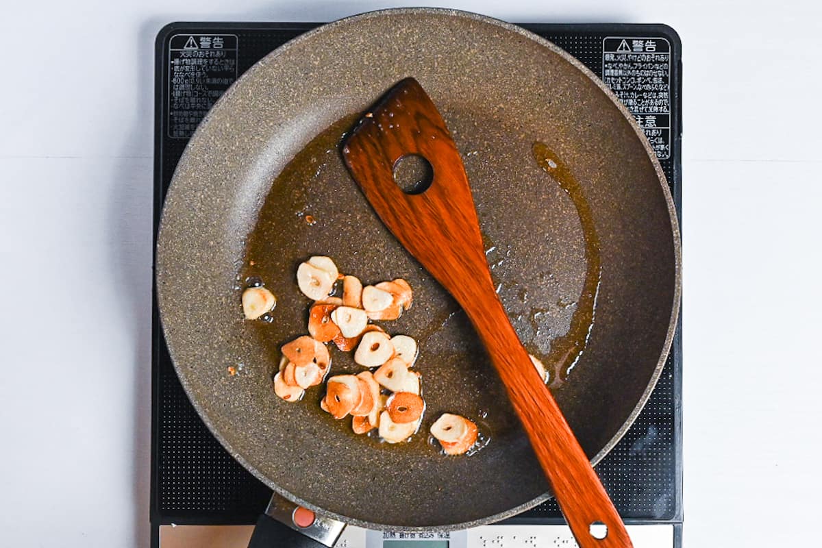 garlic slices frying in a pan