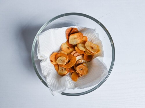 garlic chips on kitchen paper in a small glass bowl