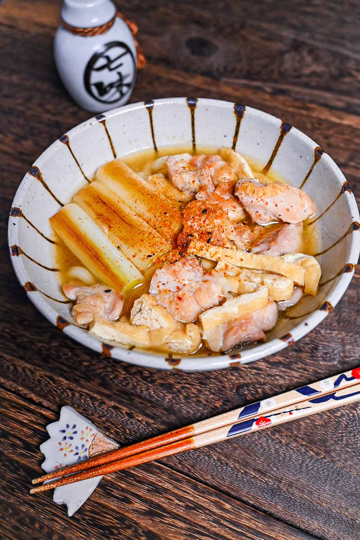 Chicken nanban udon with tofu and spring onion served in a striped bowl