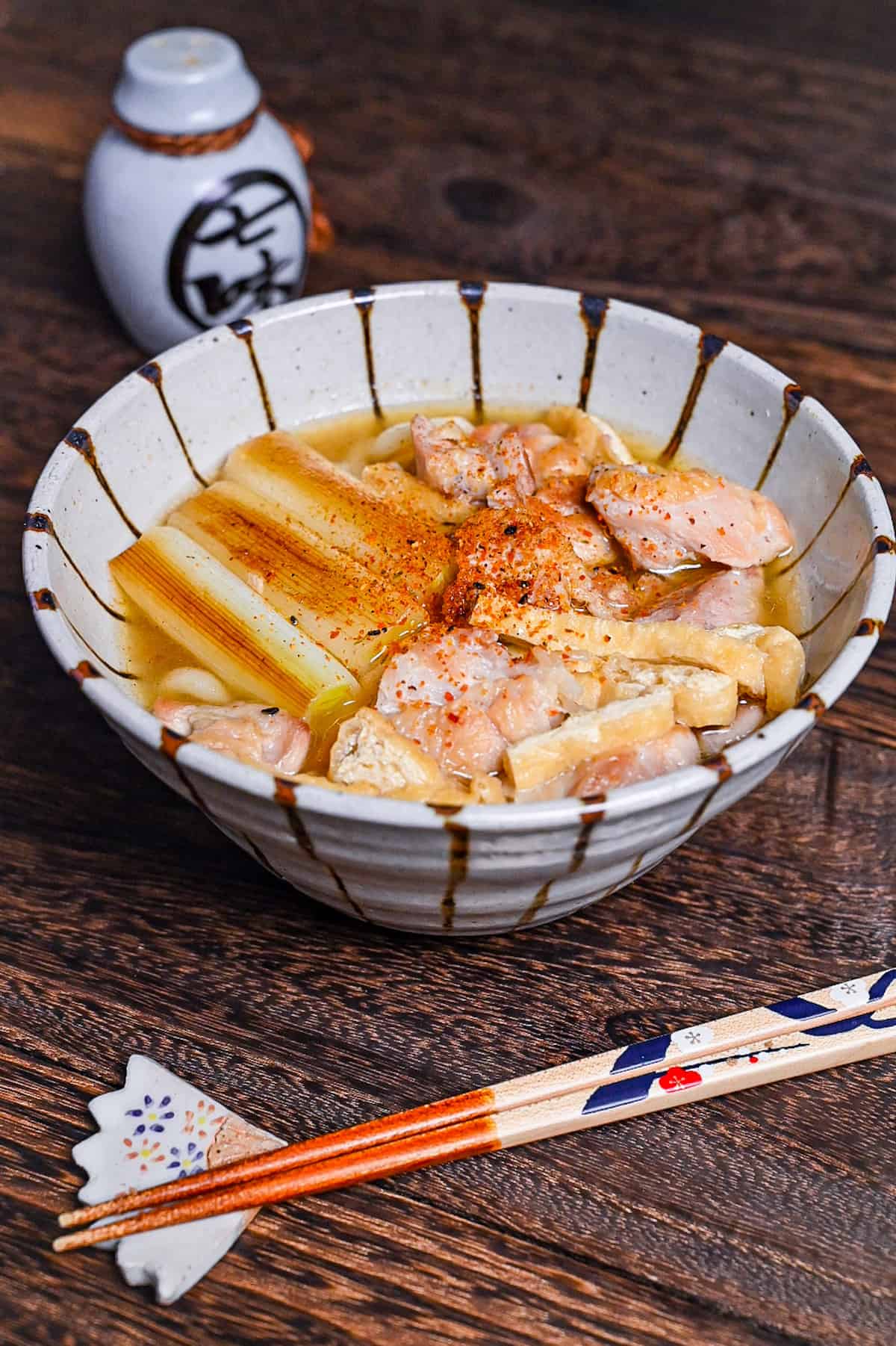 Chicken nanban udon with tofu and spring onion served in a striped bowl