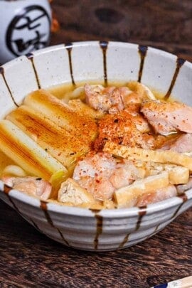 Chicken nanban udon with tofu and spring onion served in a striped bowl