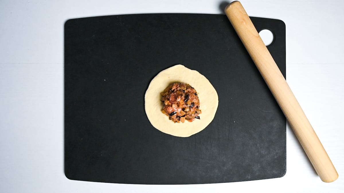 A ball of nikuman filling placed in the middle of the dough