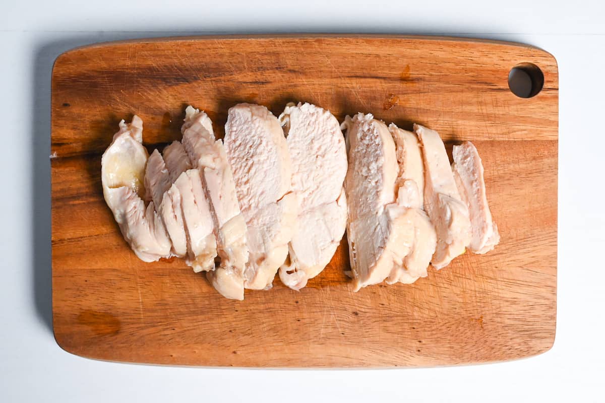 Sliced chicken breast on a wooden chopping board