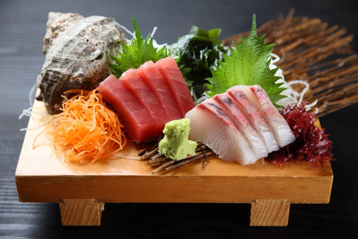 types of sashimi displayed on a wooden board