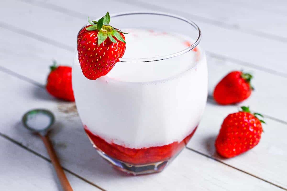 Japanese strawberry milk in a glass with a strawberry on the rim